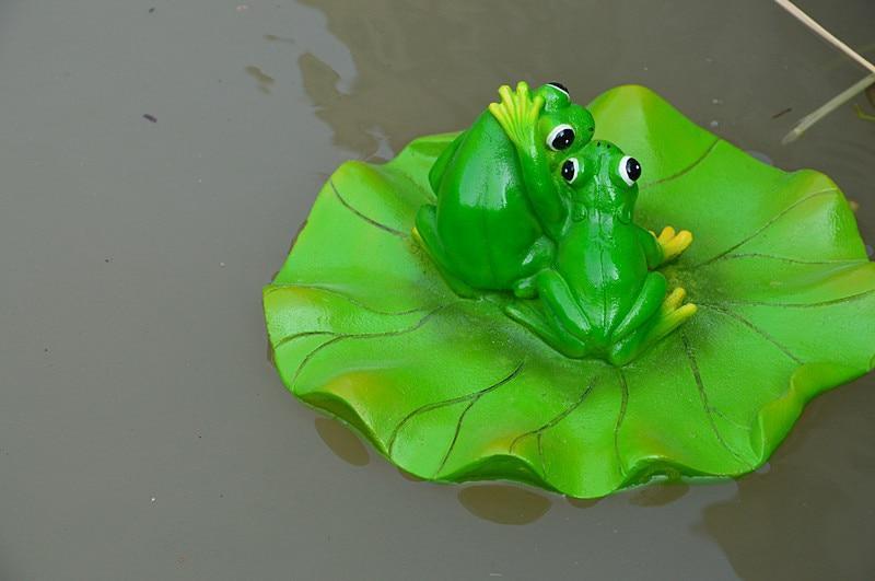 Lustige Frösche küssen auf einer Seerose. Schwimmfähig. Gartenfigur als